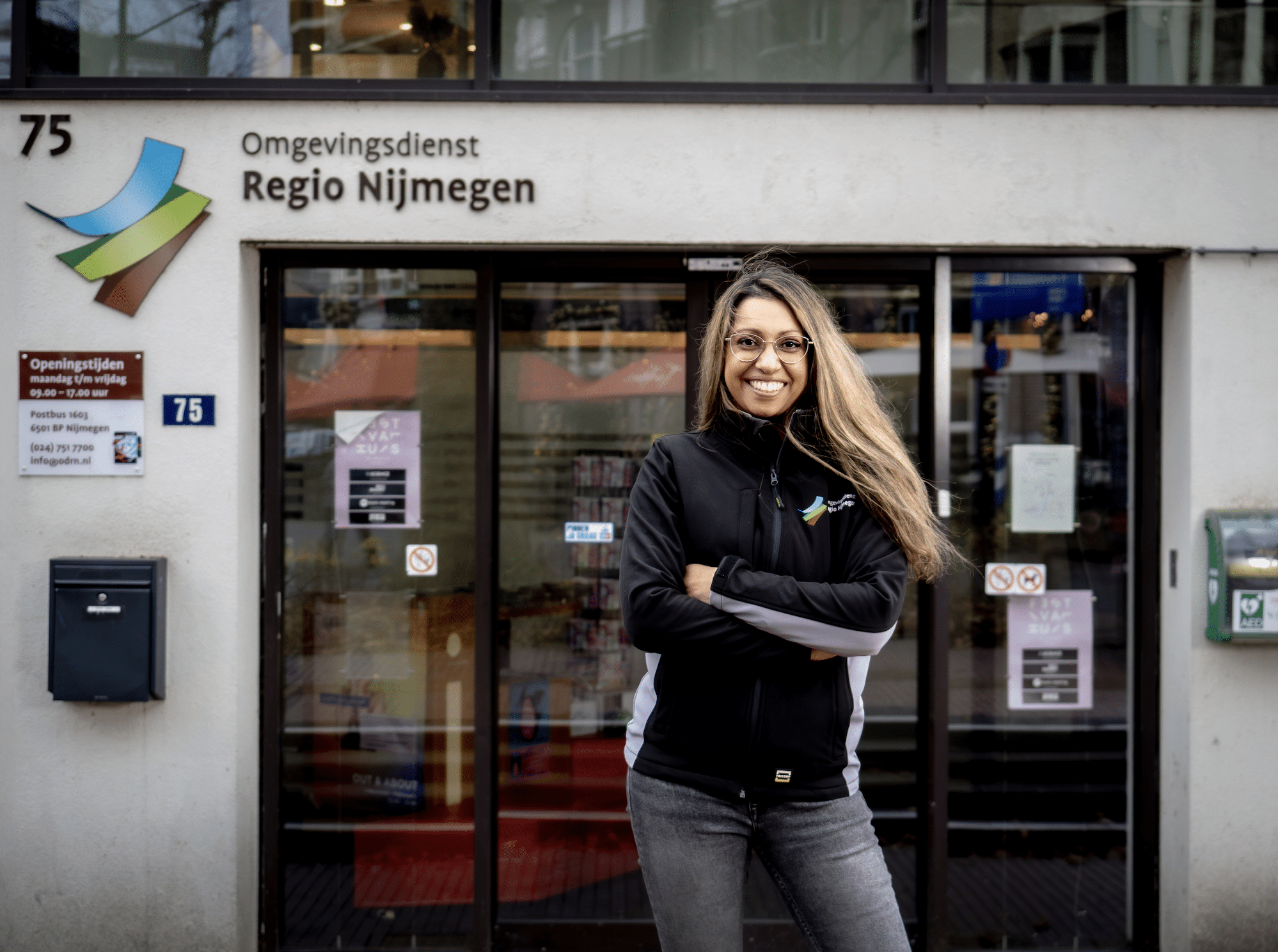 vrouwelijke medewerker staat voor het kantoorpand van ODRN